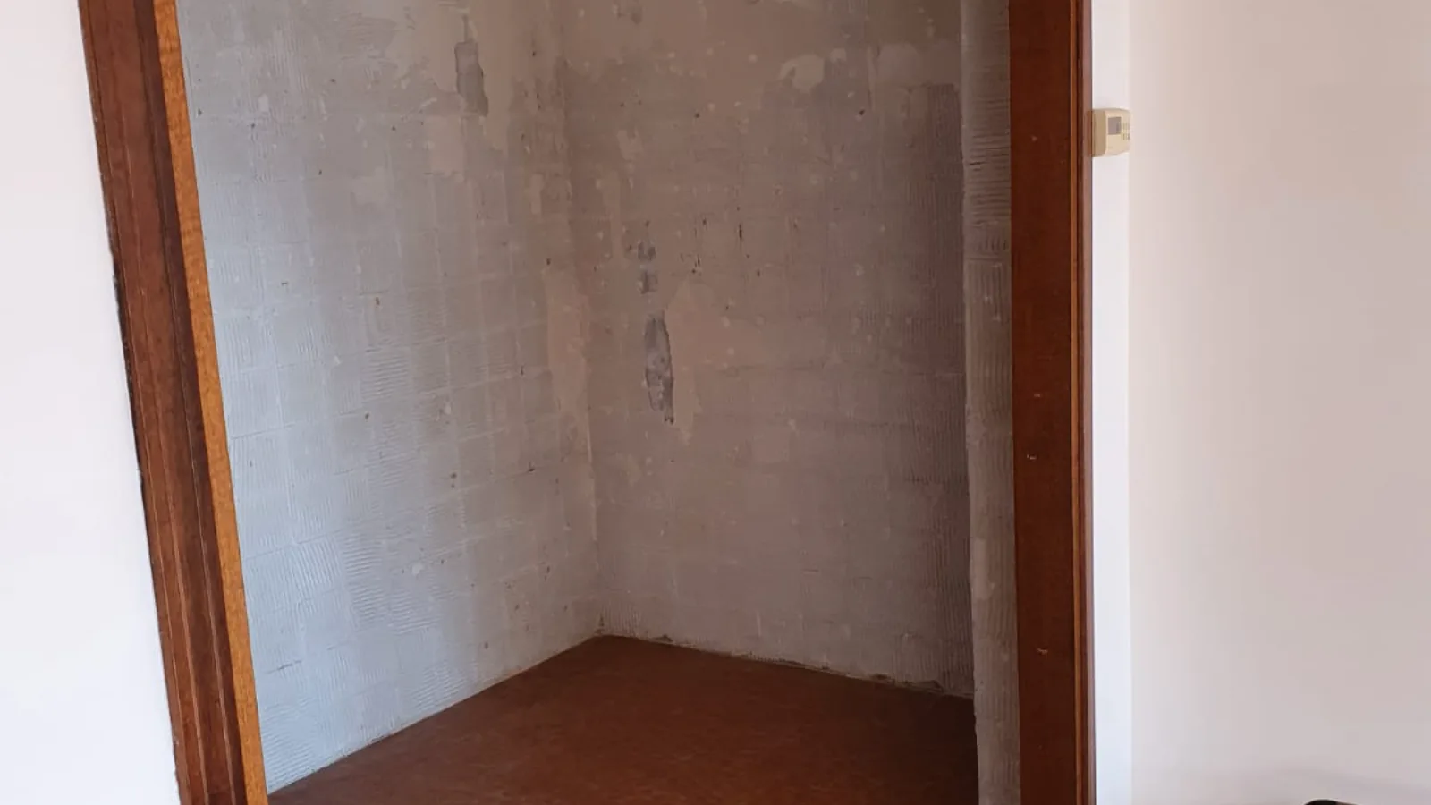 Attico SB, Verona — the same corner before the works, with the old tiled floor and stripped walls