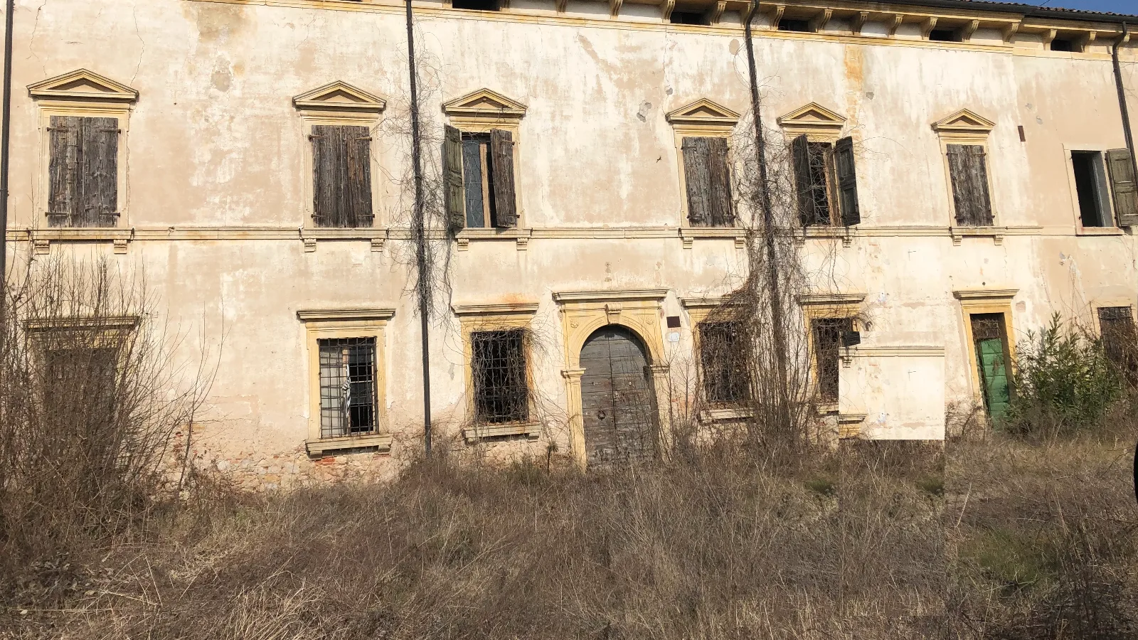 Villa Tosi before the works — the façade with peeling plaster and boarded windows